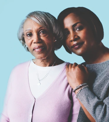 Patient portrayal of two African-American women, one with her arm around the other.