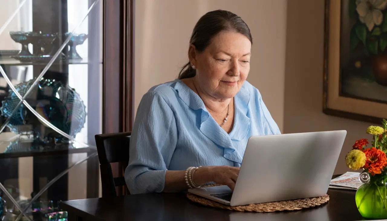 woman sitting at a table using a laptop