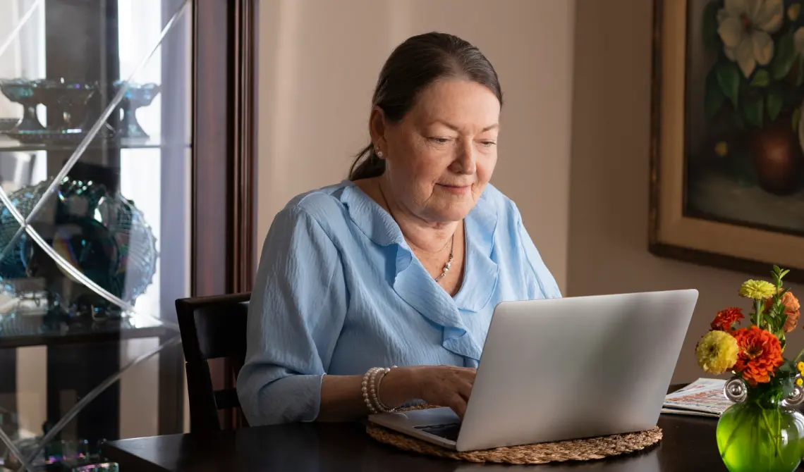 woman sitting at a table using a laptop