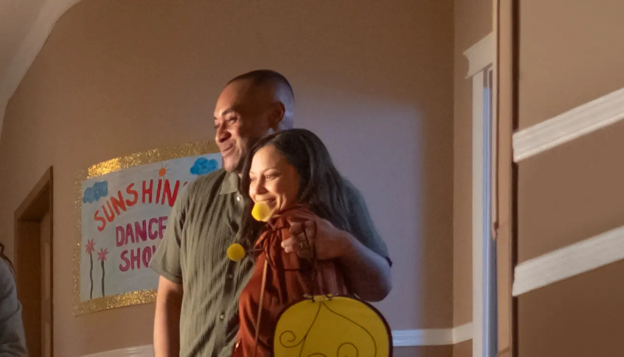 couple smiling and hugging as they stand in a school hallway