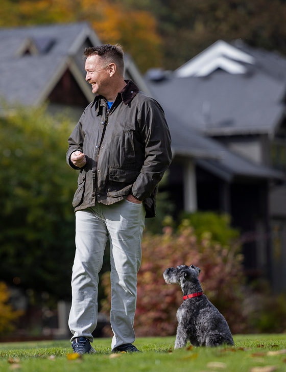 Andrew, a real ISM patient, stands outside with his dog