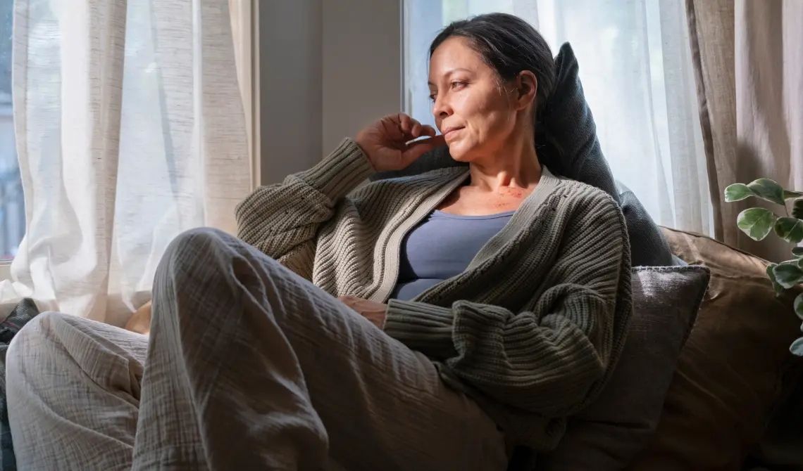 woman sitting comfortably on a couch looking peacefully out the window