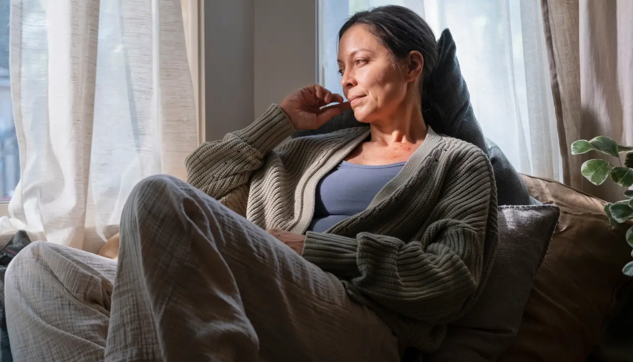 woman sitting comfortably on a couch looking peacefully out the window